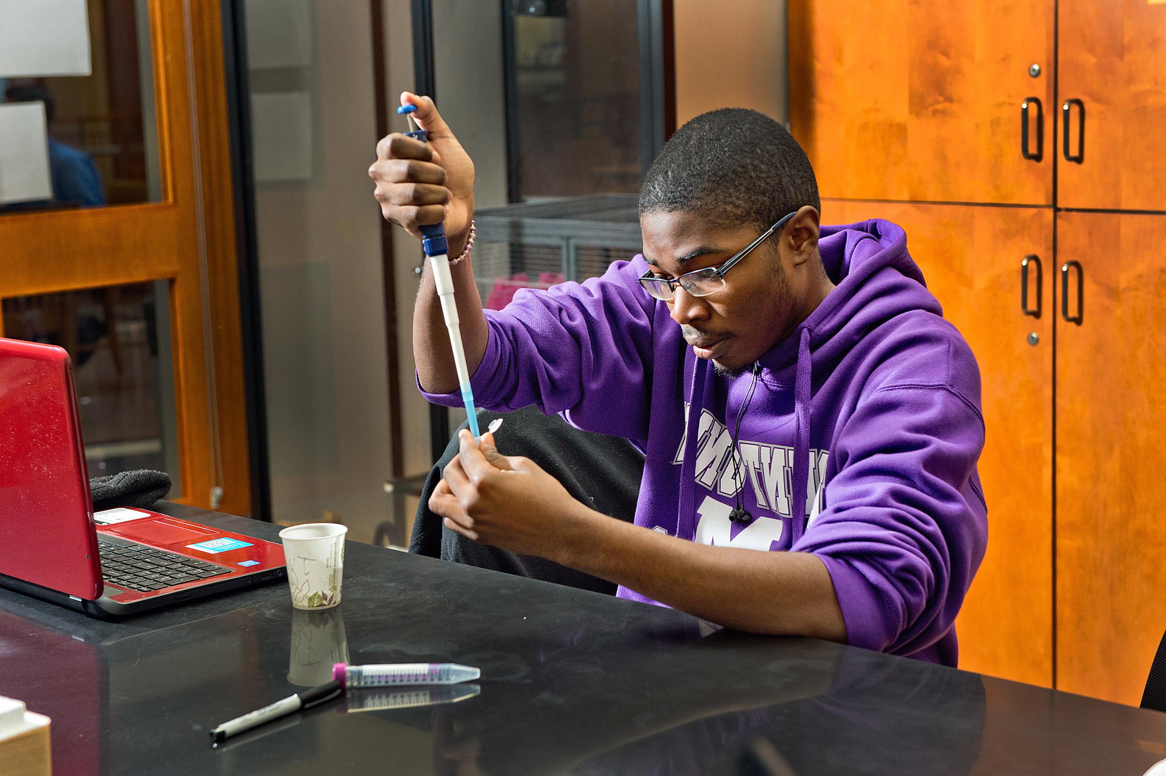 Biology student measures out a sample in a lab